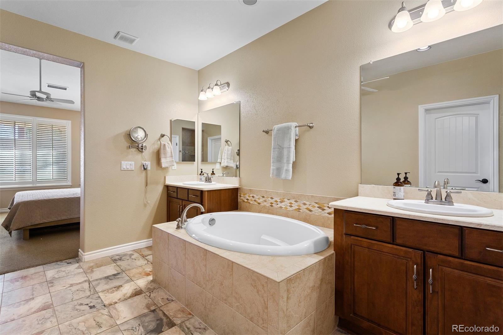 9236 Viaggio Way Highlands Ranch, CO 80126 - Photo 28 of 41 a bathroom with a tub sink and mirror