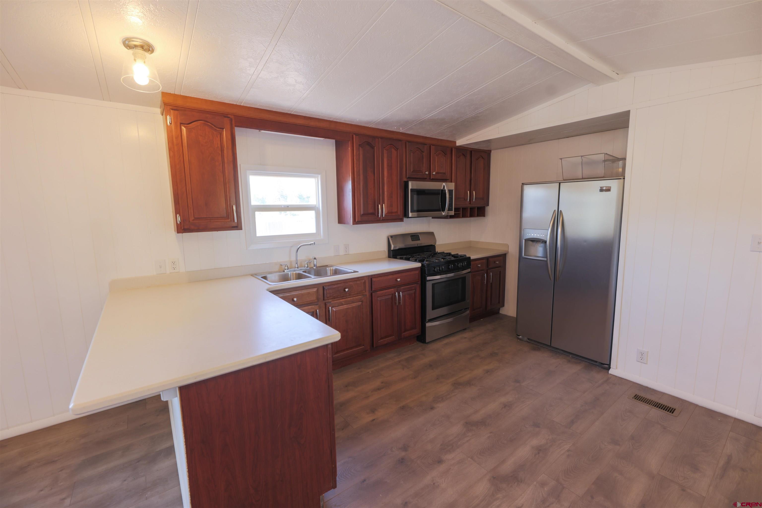 11 Rickey Place Monte Vista, CO 81144 - Photo 5 of 20 a kitchen with stainless steel appliances granite countertop a refrigerator a sink a stove a microwave a counter space and cabinets