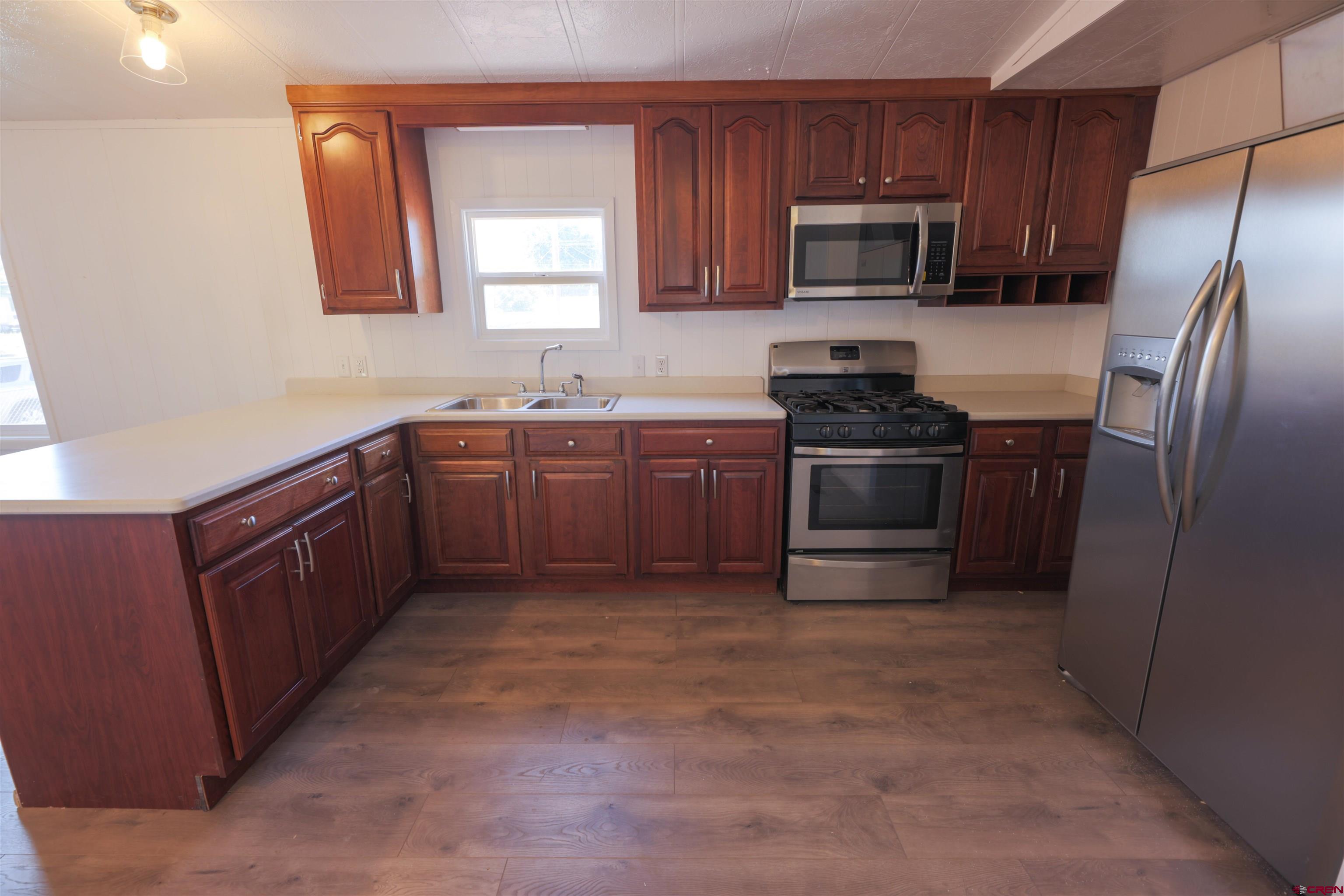 11 Rickey Place Monte Vista, CO 81144 - Photo 6 of 20 a kitchen with stainless steel appliances granite countertop a stove microwave and refrigerator