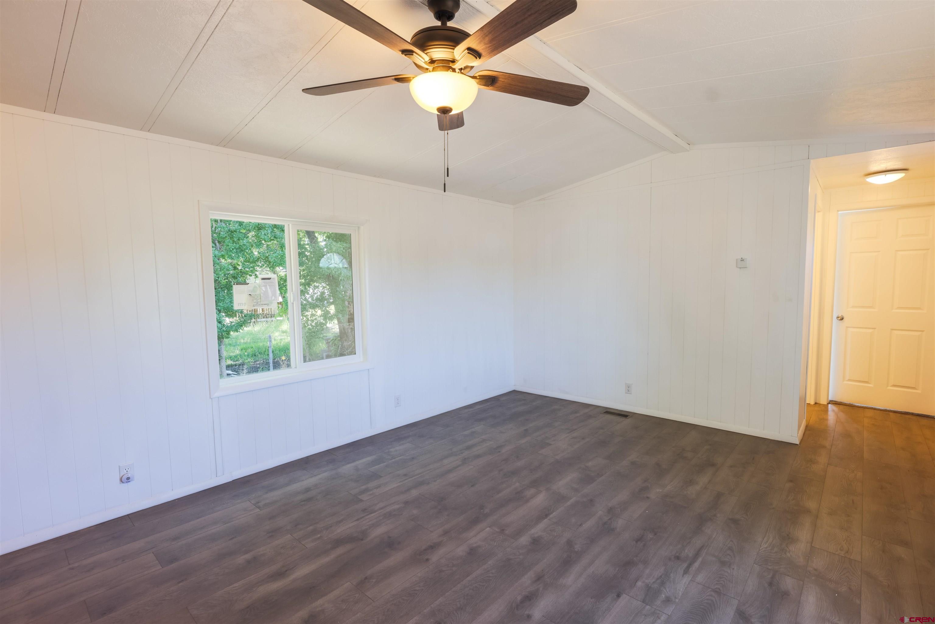 11 Rickey Place Monte Vista, CO 81144 - Photo 9 of 20 an empty room with wooden floor chandelier fan and windows