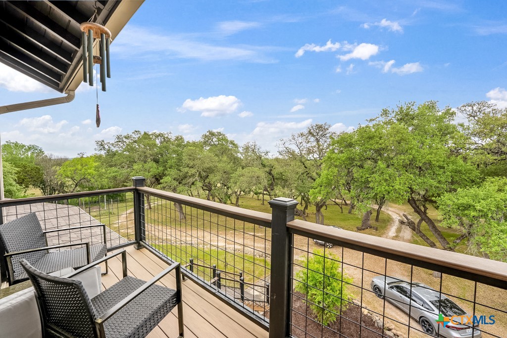 805 Sunrise Trail Spring Branch, TX 78070 - Photo 18 of 25 a view of a balcony with wooden floor and outdoor seating