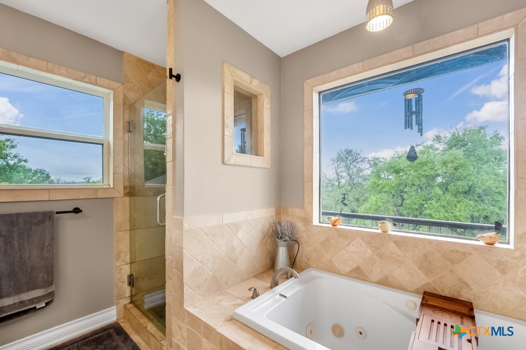 805 Sunrise Trail Spring Branch, TX 78070 - Photo 19 of 25 a bath tub sitting in a bathroom next to a window