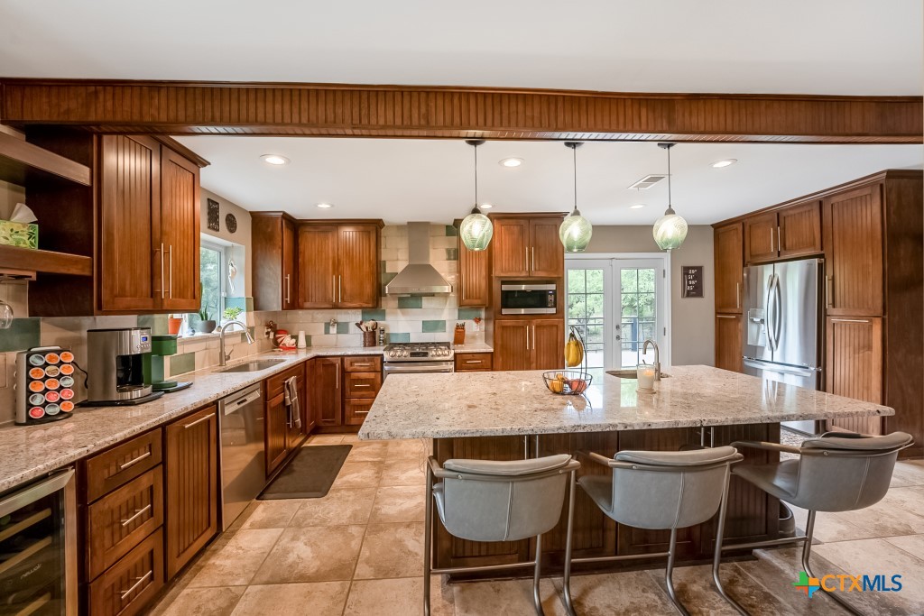 805 Sunrise Trail Spring Branch, TX 78070 - Photo 3 of 25 a kitchen with granite countertop a table chairs stove a sink and dishwasher