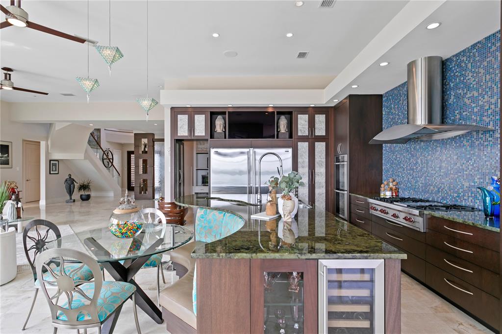 2279 Mermaid Point Northeast St. Petersburg, FL 33703 - Photo 31 of 100 a kitchen with stainless steel appliances kitchen island granite countertop a table chairs in it and wooden floors