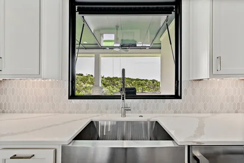 a view of a sink and dishwasher with a dining table in kitchen