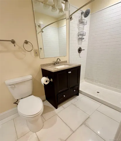a bathroom with a granite countertop sink a toilet and shower