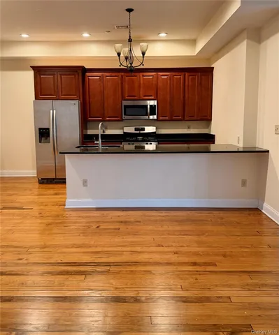 a large kitchen with stainless steel appliances granite countertop a refrigerator a stove top oven a sink and dishwasher