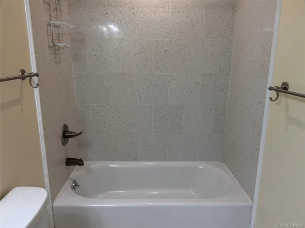 a bathroom with a granite countertop sink a toilet and shower