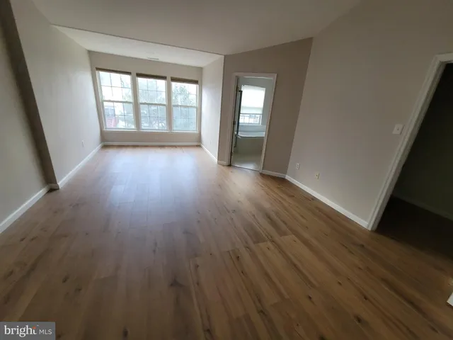 a view of empty room with wooden floor