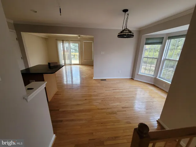 a view of empty room with wooden floor and stairs