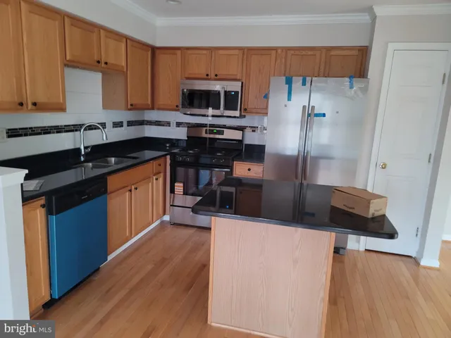 a kitchen with stainless steel appliances a refrigerator stove microwave and sink