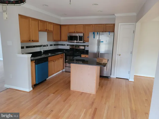 a kitchen with stainless steel appliances a microwave a stove a sink dishwasher a refrigerator and a microwave