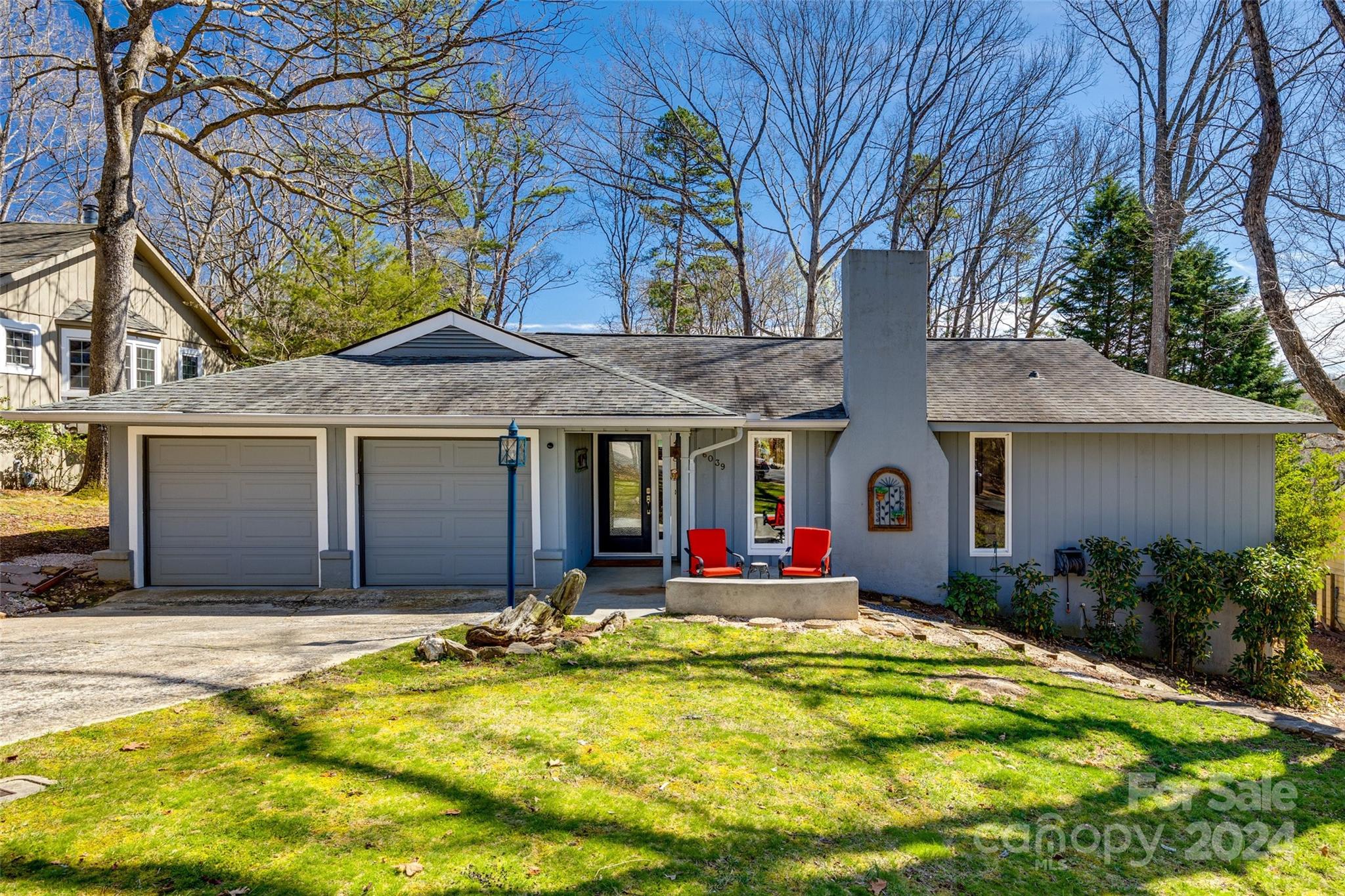 a front view of house with yard and trees in the background