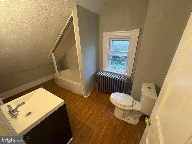 a bathroom with a toilet a sink and a window