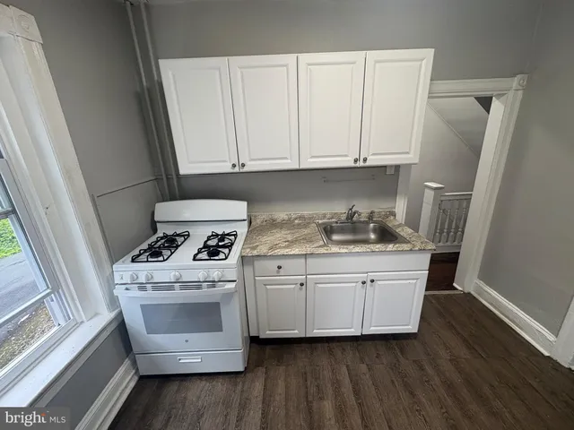 a kitchen with white cabinets and white appliances