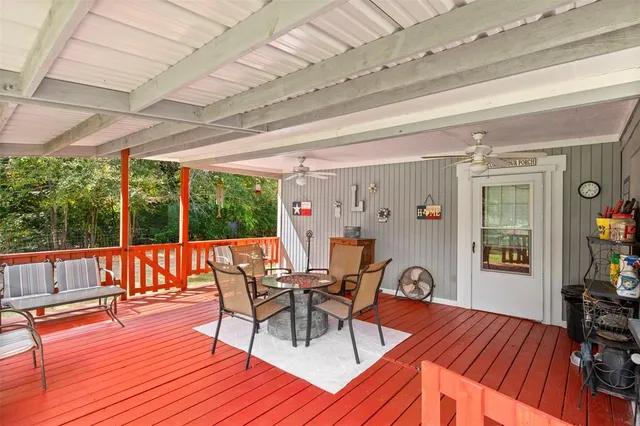 a view of a patio with table and chairs potted plants with wooden floor and walls