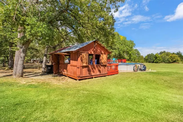 a view of a house with pool and a yard