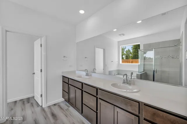 a bathroom with a sink double vanity granite tub shower and a mirror