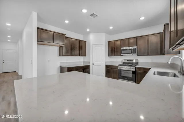 a kitchen with stainless steel appliances a microwave a sink and a refrigerator