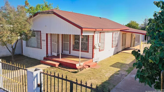 a view of a house with backyard and sitting area