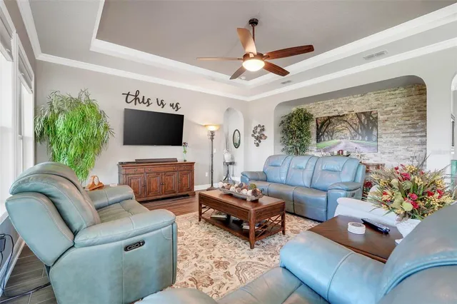 a living room with furniture a flat screen tv and a potted plant