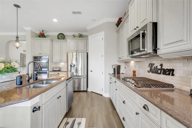 a kitchen with stainless steel appliances granite countertop a sink stove and refrigerator