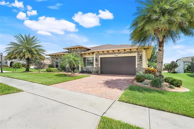 a view of a house with a yard and palm trees