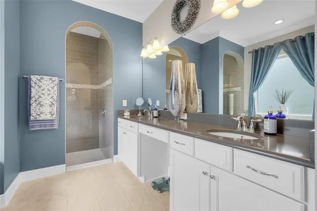 a en suite spacious bathroom with a granite countertop sink and a mirror