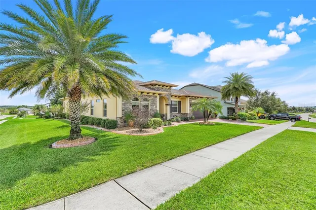 a front view of a house with garden and trees