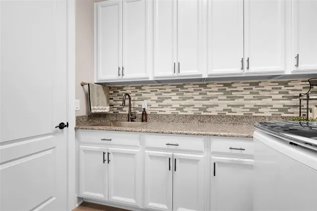 a kitchen with a sink and a stove with wooden floor
