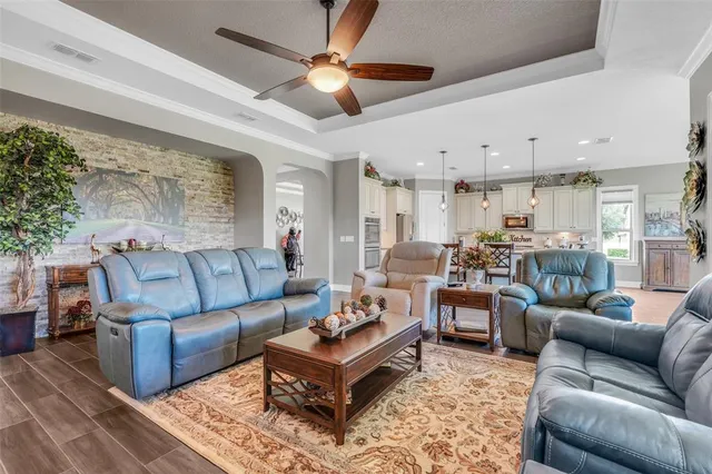 a living room with furniture kitchen view and a chandelier