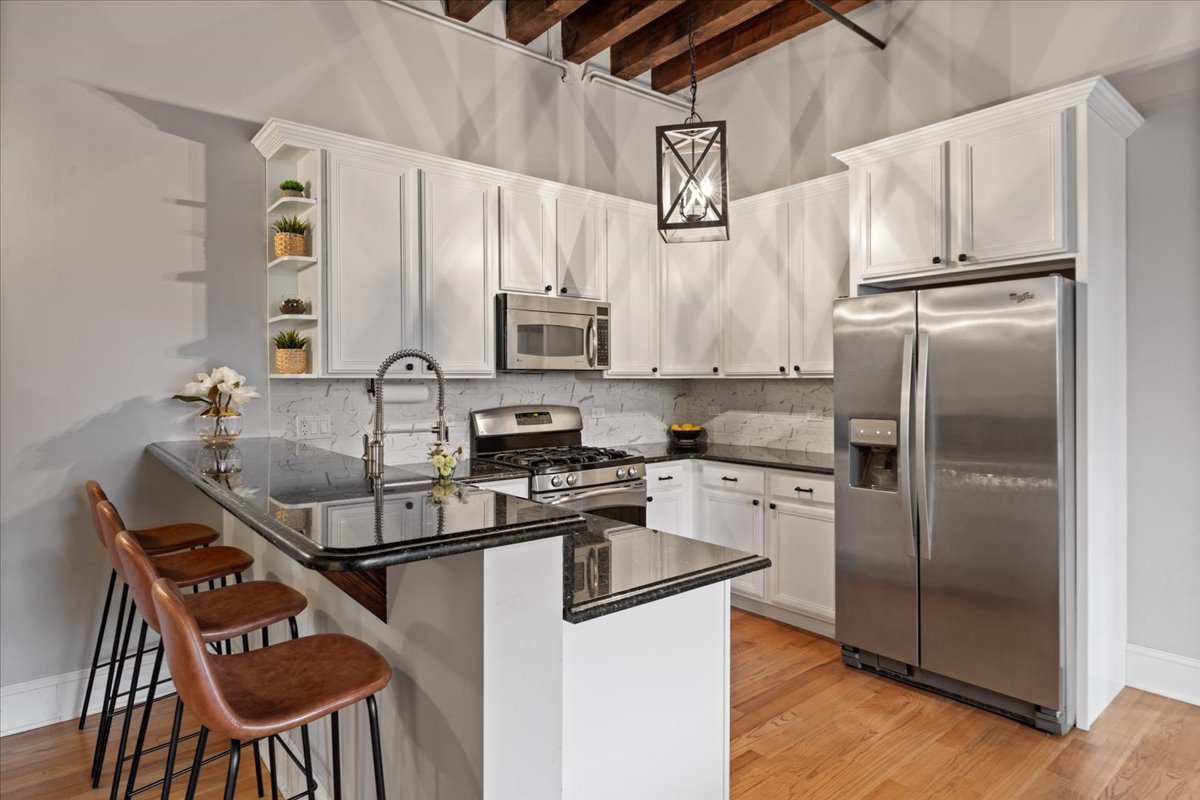 2310 West Nelson Street, Unit 302 Chicago, IL 60618 - Photo 2 of 20 a kitchen with stainless steel appliances granite countertop a sink a stove a refrigerator cabinets and chairs