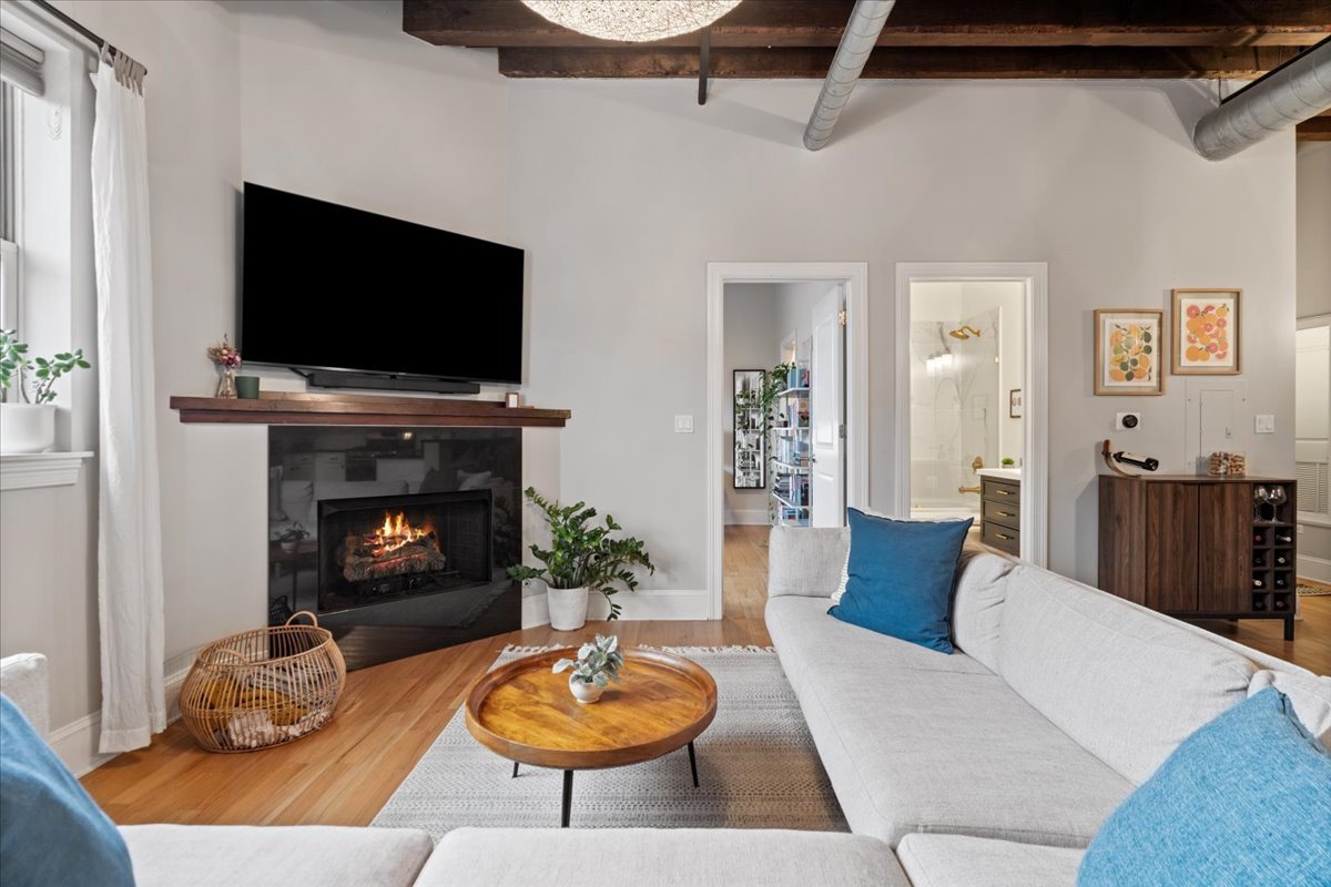 2310 West Nelson Street, Unit 302 Chicago, IL 60618 - Photo 7 of 20 a living room with furniture a flat screen tv and a fireplace