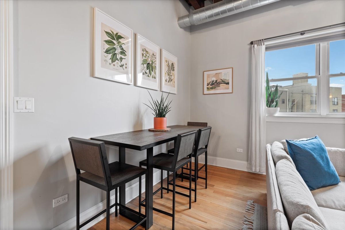 2310 West Nelson Street, Unit 302 Chicago, IL 60618 - Photo 10 of 20 a view of a dining room with furniture window and wooden floor