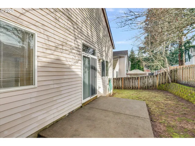 a view of backyard with wooden fence