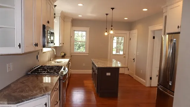 a kitchen with stainless steel appliances granite countertop a refrigerator a sink and wooden cabinets
