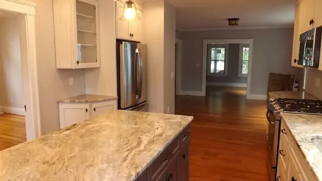 a kitchen with kitchen island a counter top space a sink appliances and cabinets