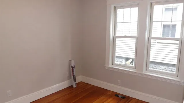a view of a room with wooden floor and windows