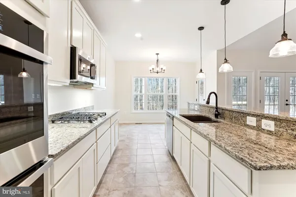 a kitchen with stainless steel appliances granite countertop a sink stove and cabinets