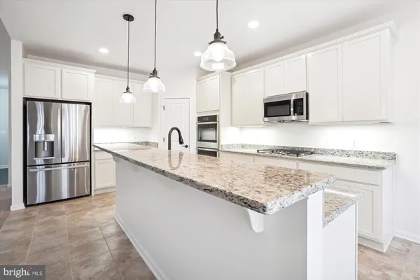 a kitchen with stainless steel appliances granite countertop a sink a stove and a refrigerator