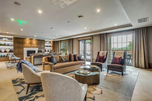 a living room with furniture a fireplace and a floor to ceiling window