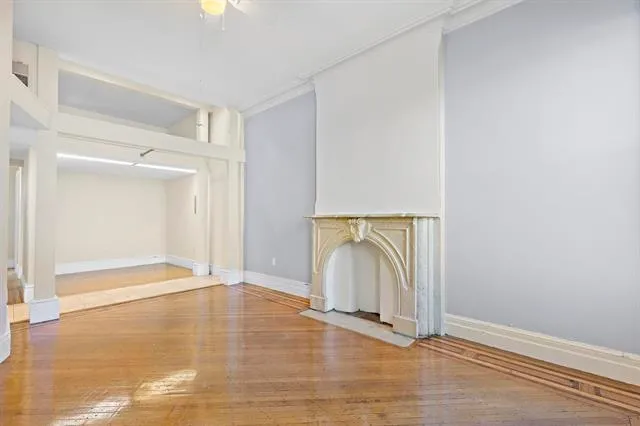 an empty room with wooden floor and mirror
