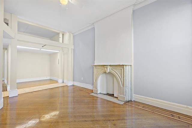an empty room with wooden floor and mirror