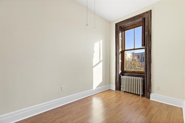 910 Hudson Street, Unit 3 Hoboken, NJ 07030 - Photo 12 of 14 an empty room with wooden floor and windows