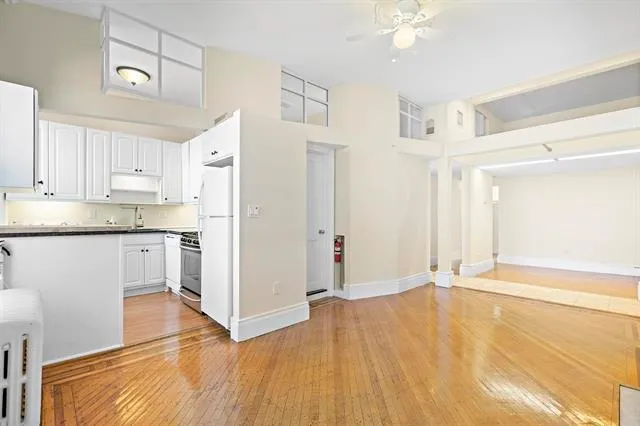 a view of a kitchen with wooden floor and a refrigerator