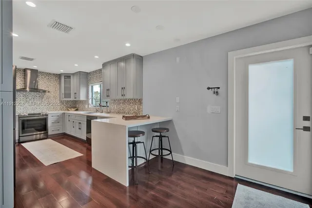 a kitchen with a sink cabinets and wooden floor