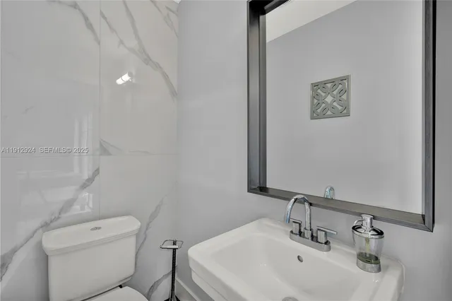 a bathroom with a toilet a sink and mirror