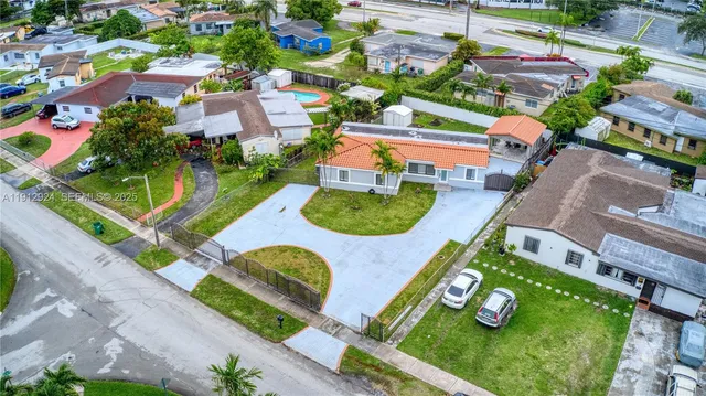 an aerial view of residential houses with outdoor space and swimming pool
