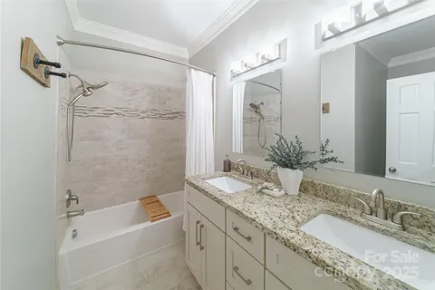 a bathroom with a granite countertop sink mirror and a bath tub