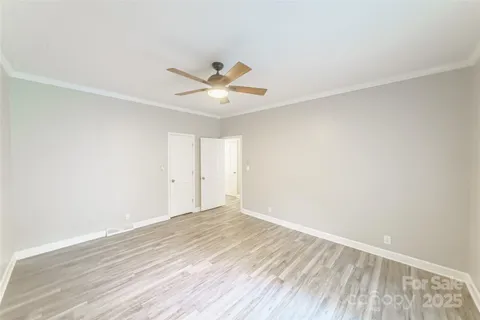 a view of a room with wooden floor and a ceiling fan